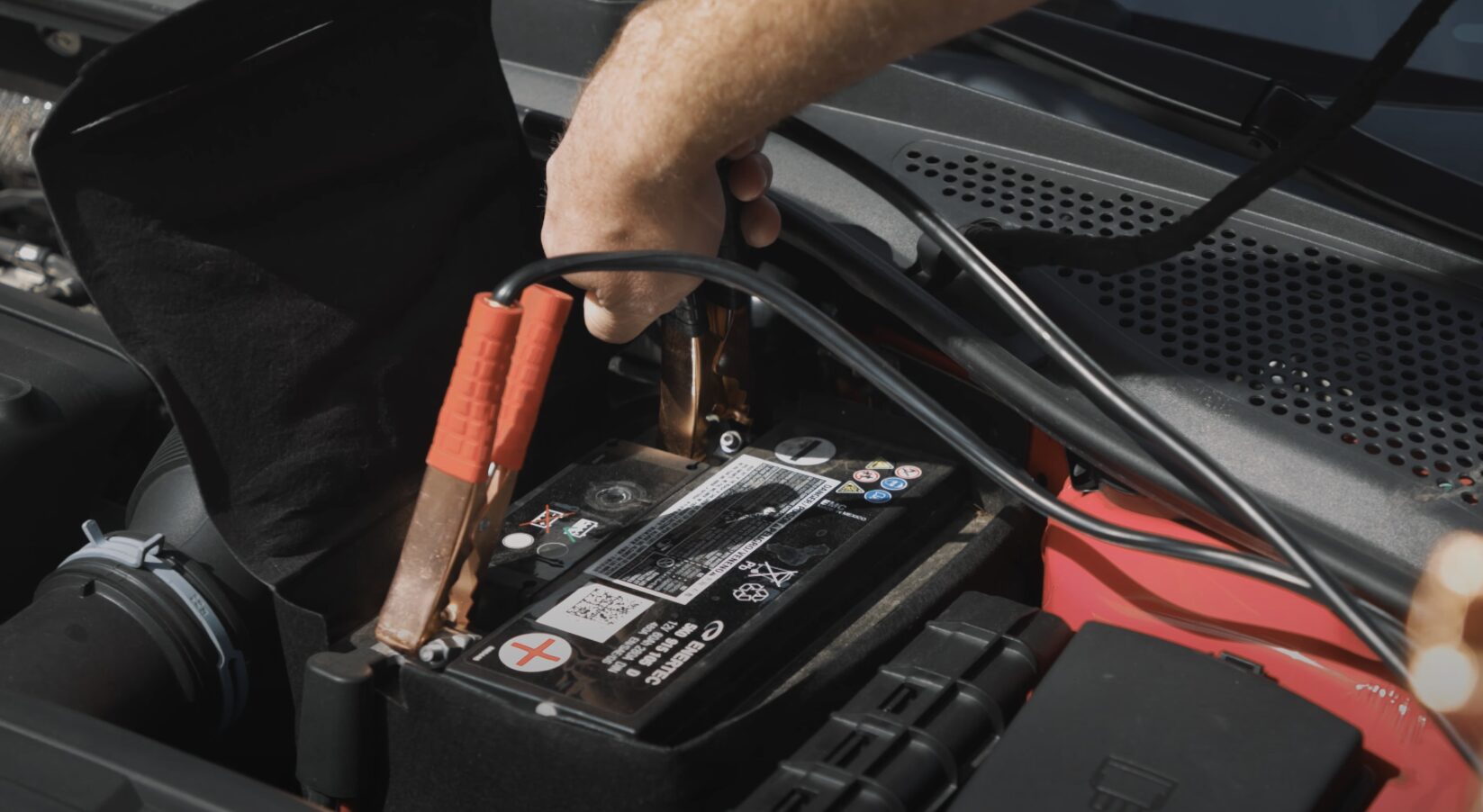Professional Roadside Assistance Service Roadside assistance technician jump starting a car battery